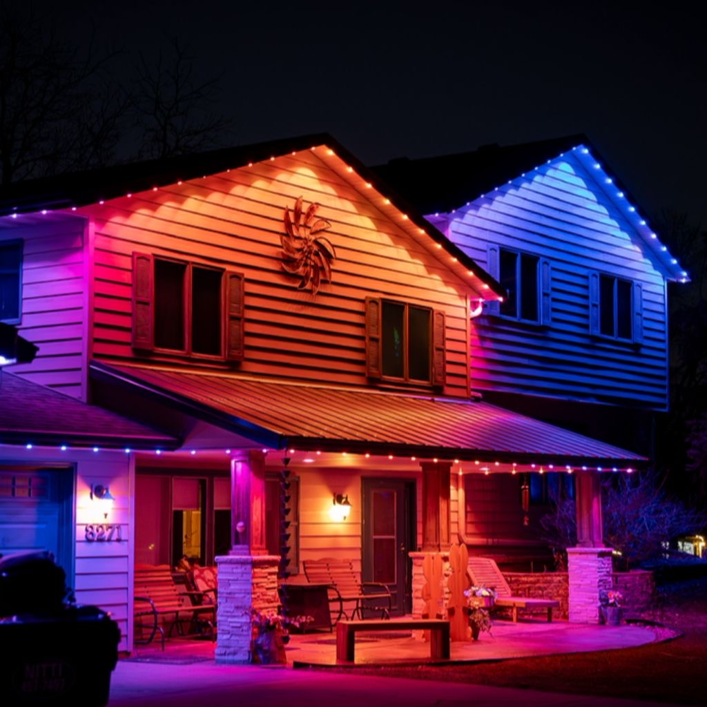 Home wrapped in multicolor permanent LED lighting across gables, porch and eaves